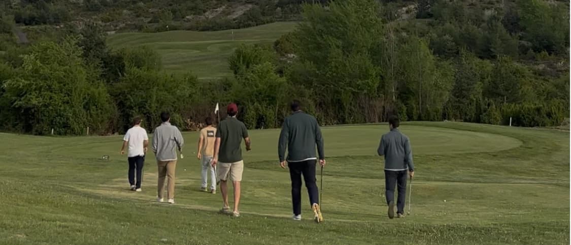 Seis golfistas caminando por la calle hacia el green